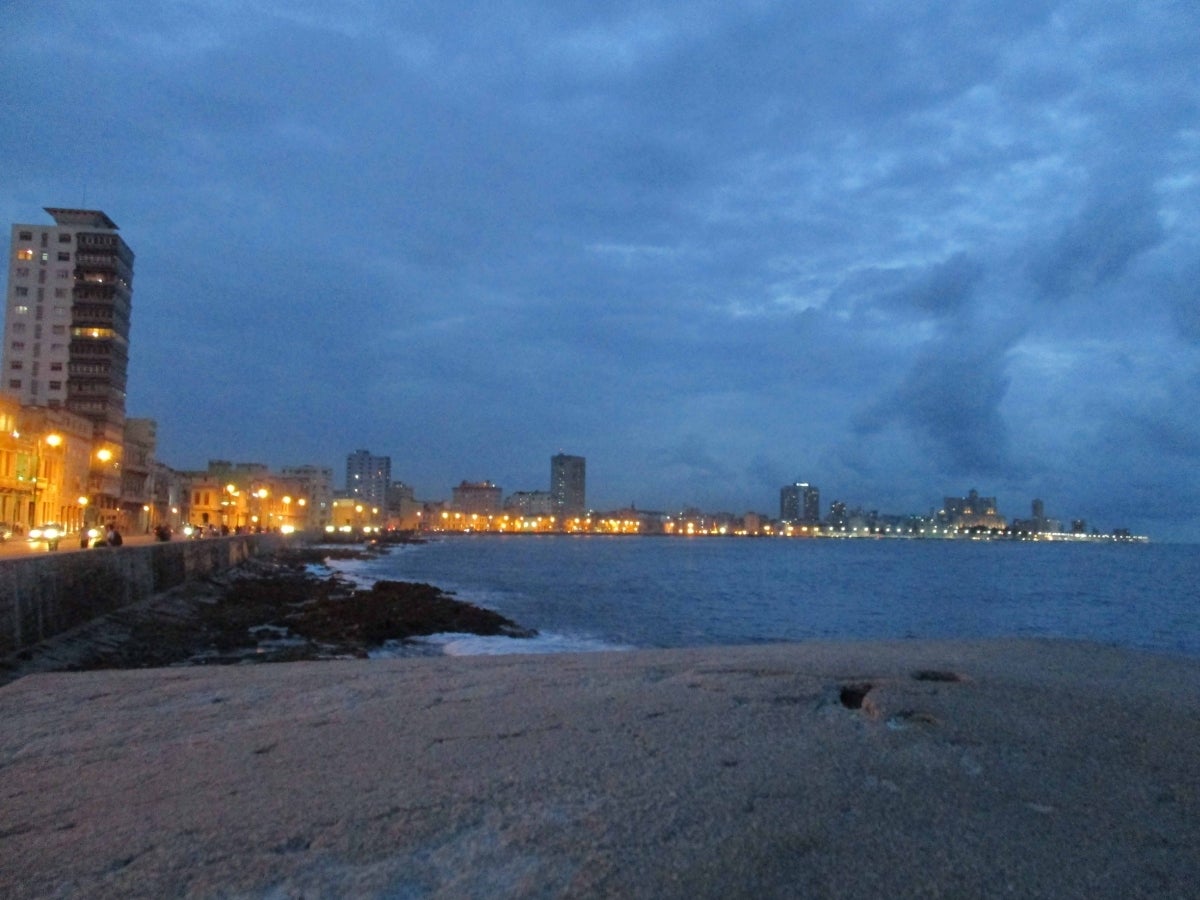 The Caribbean Sea lapping a seawall in Havana Cuba with buildings in the distance