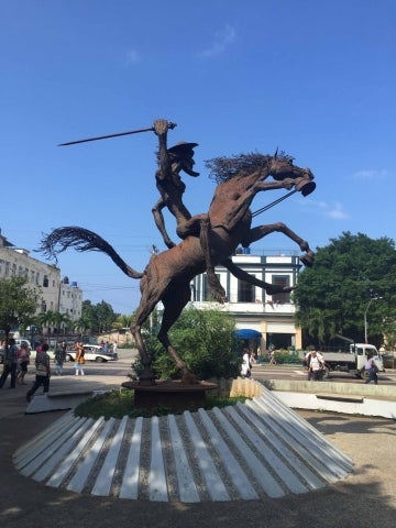 Metal statue of Don Quixote on a horse in a plaza