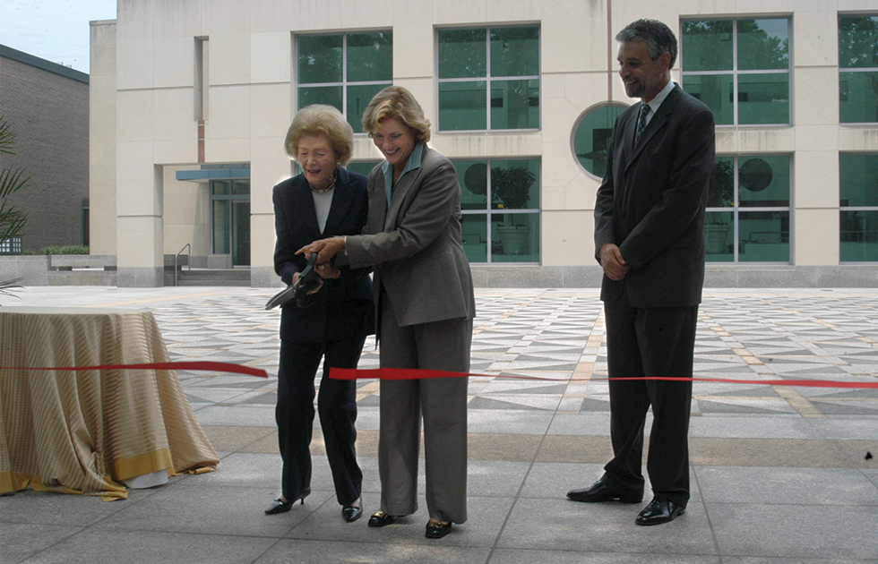 Leonore Annenberg and Judith Rodin cutting a ceremonial red ribbon on the Annenberg Plaza while Michael Delli Carpini Looks on