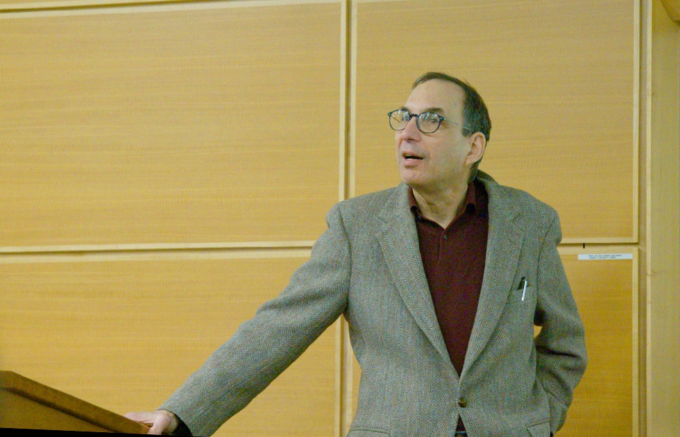 Joseph Turow speaking in front of a wood paneled wall
