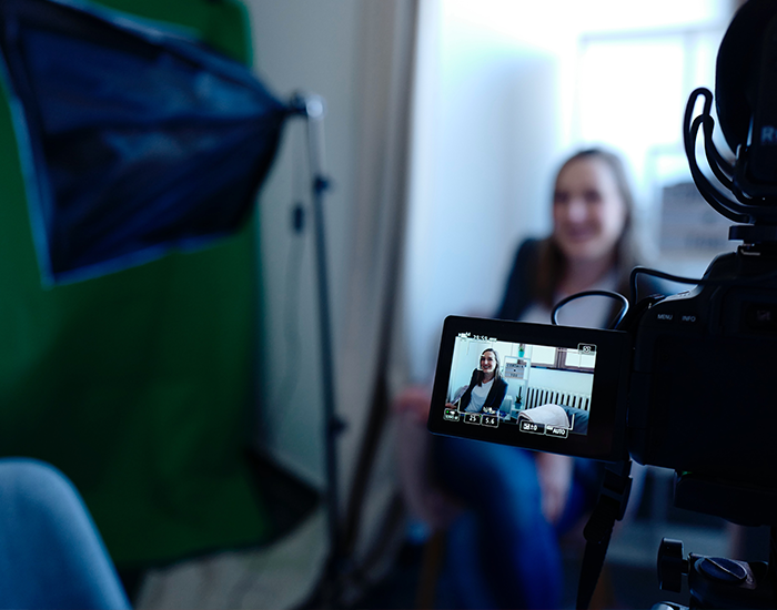 Woman being filmed for an interview, Photo Credit to CoWomen on Unsplash