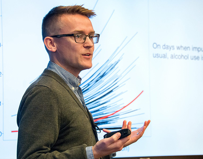 AHA Director standing in front of a screen giving a lecture
