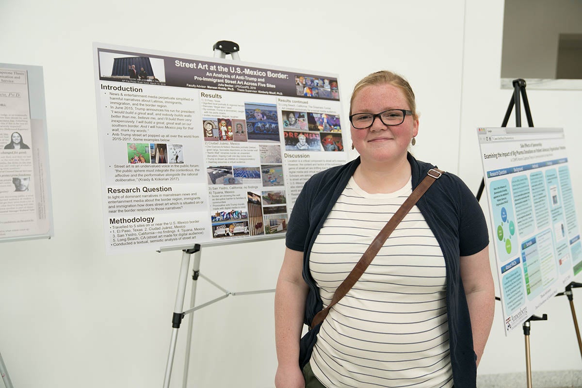 Julia Becker poses with thesis poster.