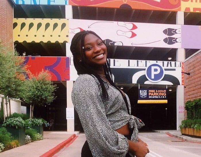 Raven Sulaimon posing in front of a colorfully-painted parking garage
