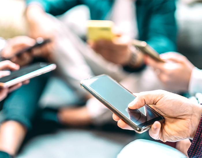 Misinformation_Checkerboard.png View of five people holding iPhones, only hands are visible