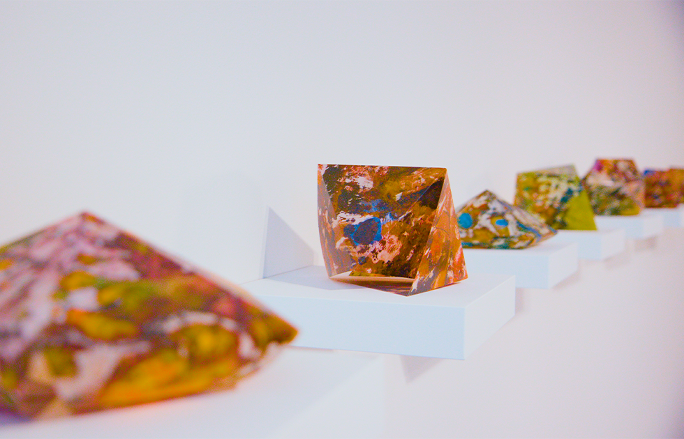 Colorful geometric 3D shapes laying on a white shelf