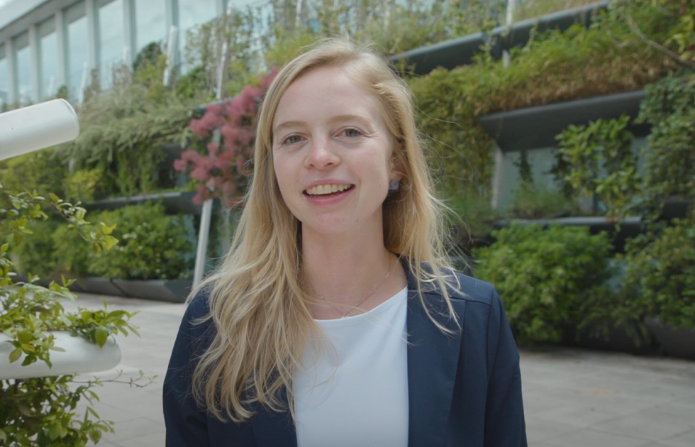 A woman smiling at the camera as she's being interviewed outdoors