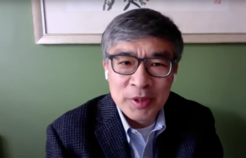 Guobin Yang speaking against a green wall