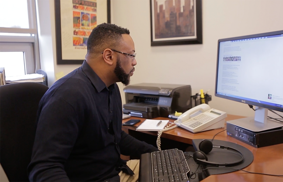 Desmond Upton Patton, Ph.D. in office, looking at computer