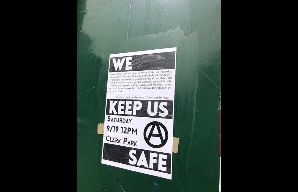 Sign that says “We Keep Us Safe” and reads “Proud Boys are coming to West Philly on Saturday, September 19th to hold rally in ‘the belly of the beast.’ A far right, neo-fascist organization, the Proud Boys are racist, anti-trans, anti-immigrant, explicitly colonialist, anti-Muslim, misogynist, and generally authoritarian, using street violence across the U.S. to impose their politics on the rest of us. We intend to drive them out of our neighborhood. Saturday 9/19 12 PM Clark Park” and a logo with an A in a