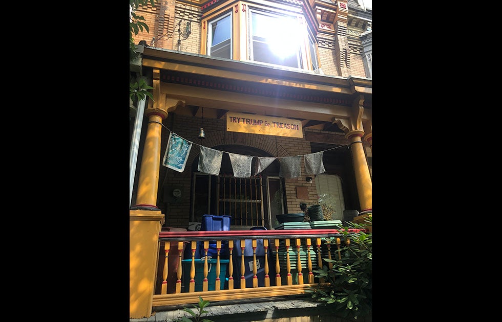 porch with a homemade banner that reads “Try Trump for Treason”