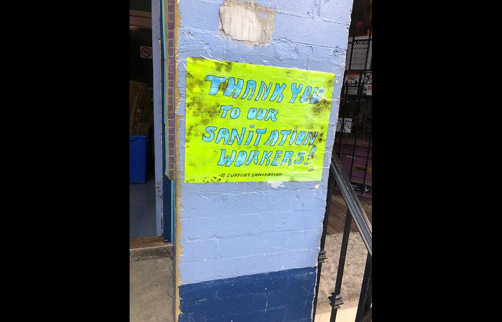 Handmade sign that says “Thank you to our sanitation workers! #SupportSanitation” posted to the side of a building.