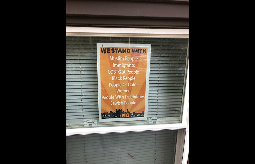Sign in a window that says “We stand with Muslim People/Immigrants/LGBTQIA People/Black People/People of Color/Women/People With Disabilities/Jewish People/Philly says NO to Hate”