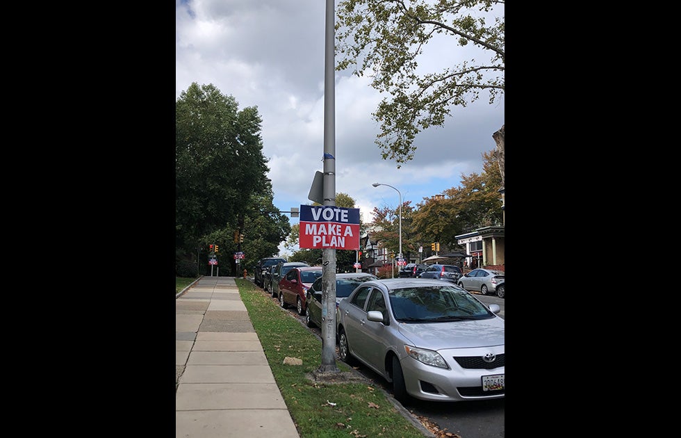 “Black Lives Matter” sign amongst pine cones, leaves, and plants.