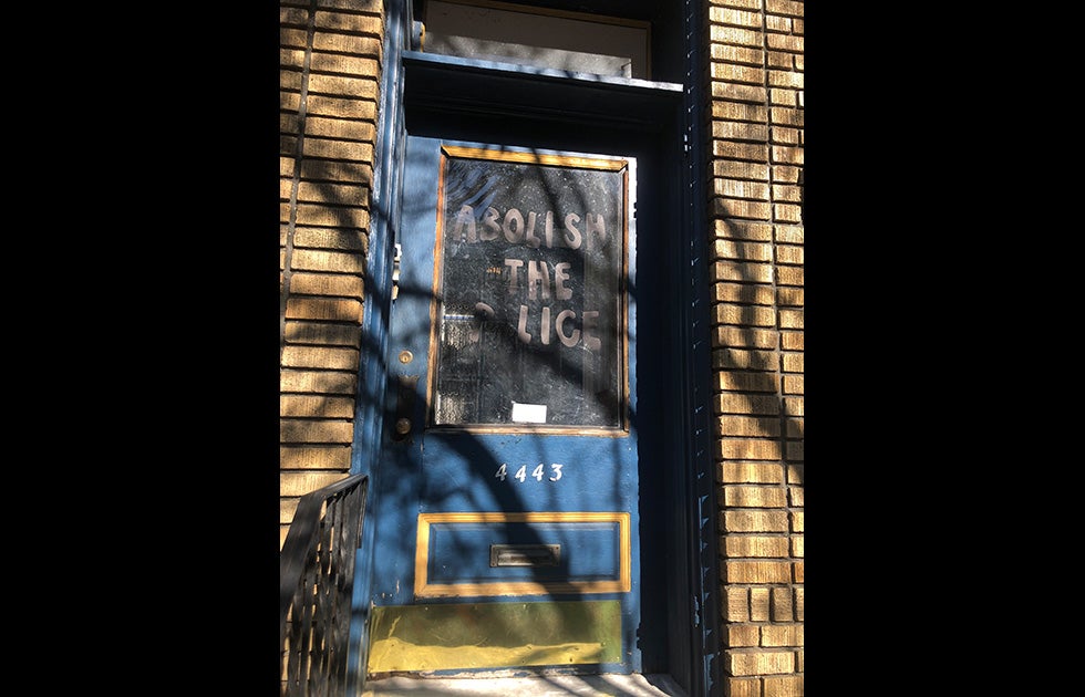 apartment door with “Abolish the police” written on the glass window.