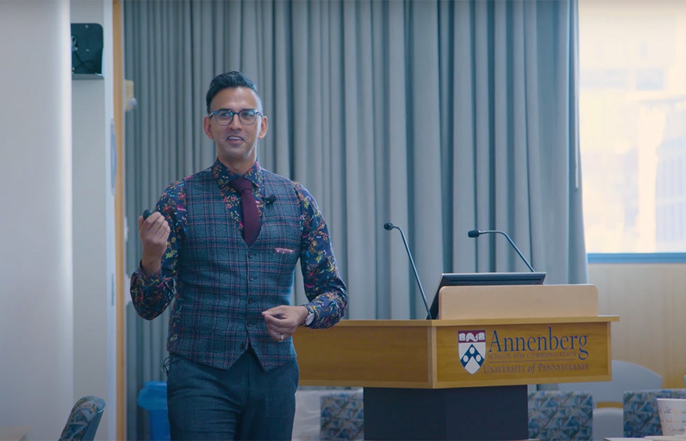Christopher Ali delivering lecture in front of Annenberg School for Communication branded podium.