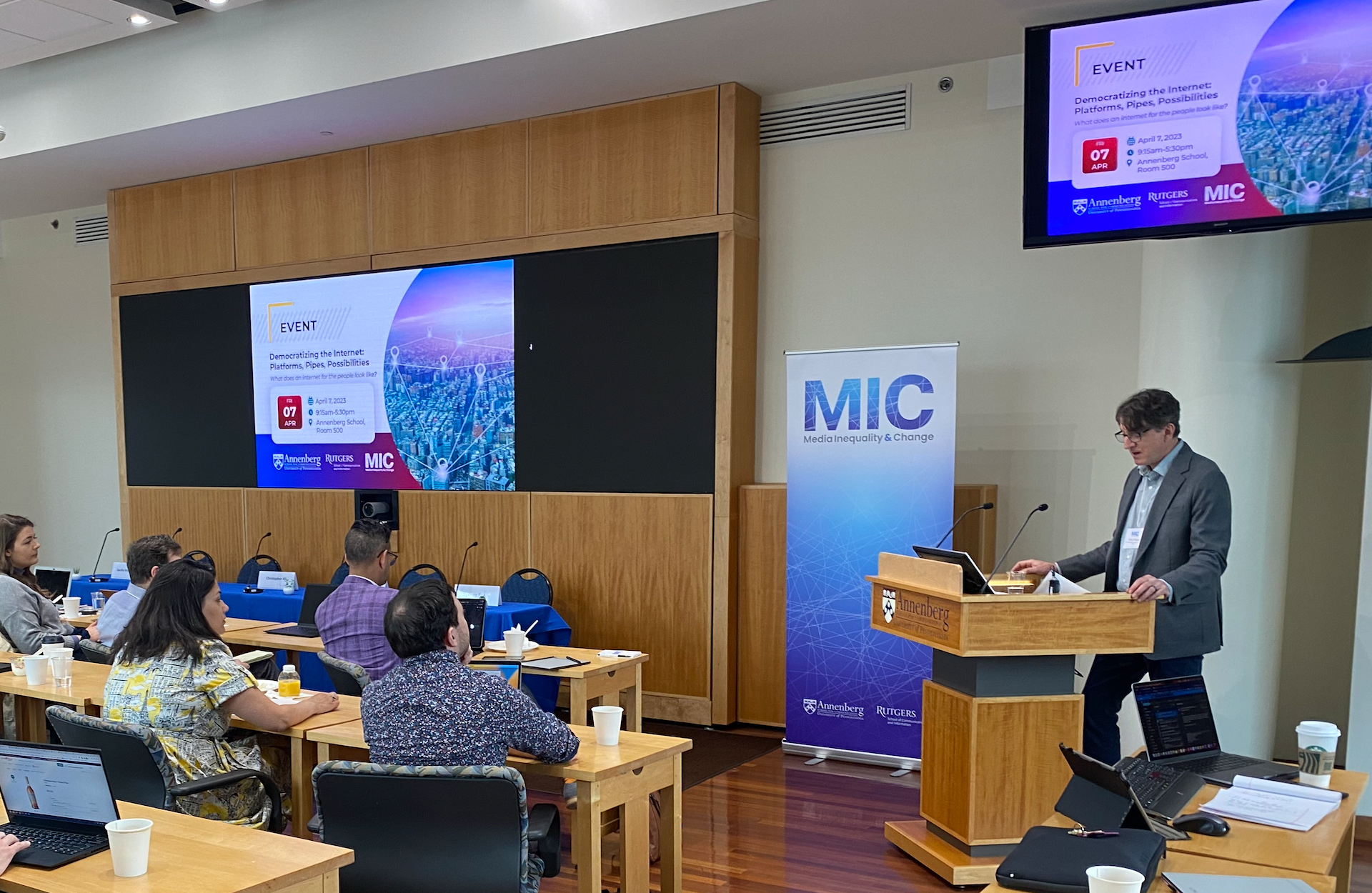 Professor Victor Pickard speaks at a podium to an audience