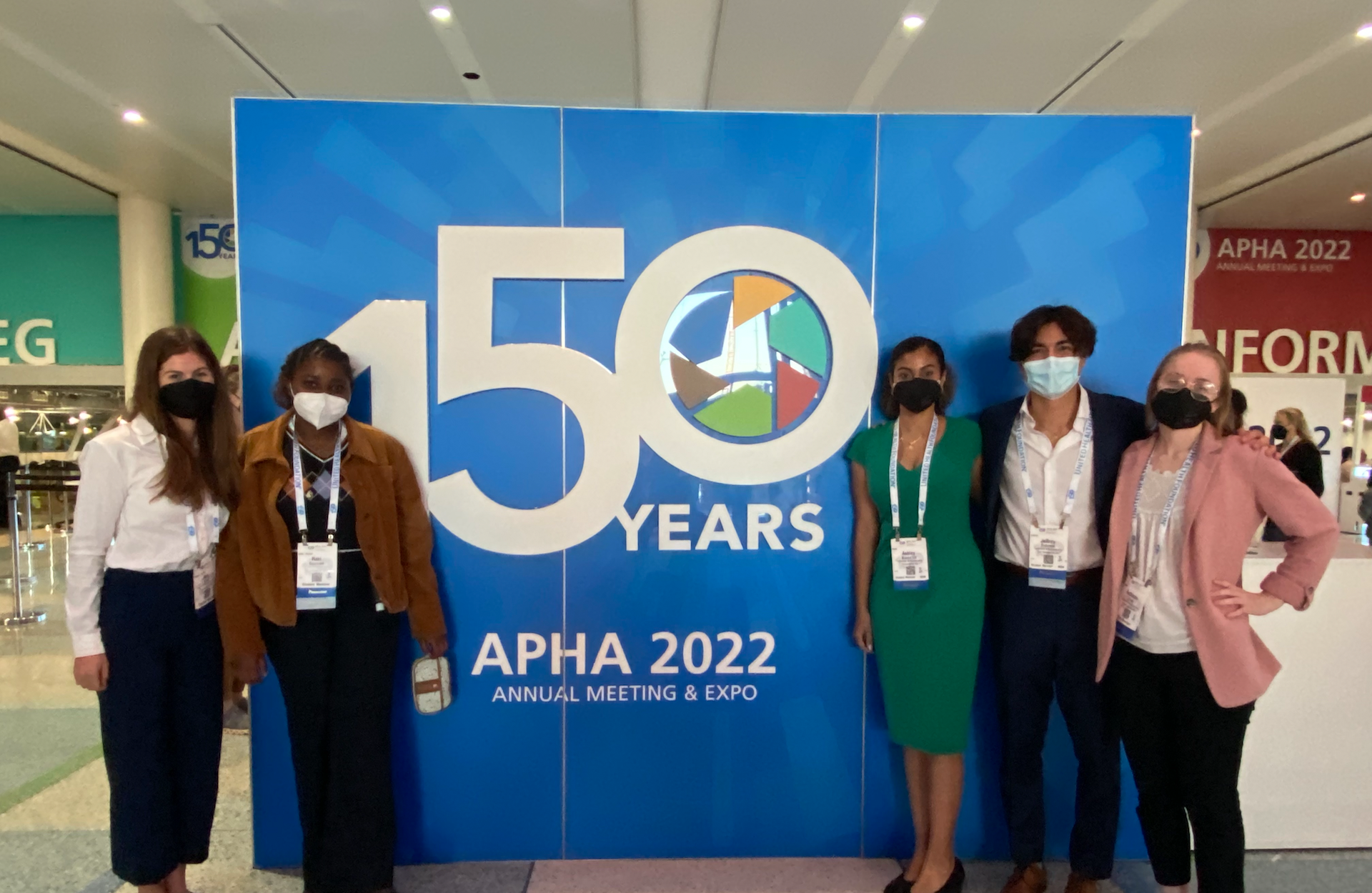 conf 1920 1250.png Students pose in front of a banner reading APHA 2022