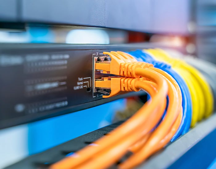 Colorful network cables connected on network switches panel in data center