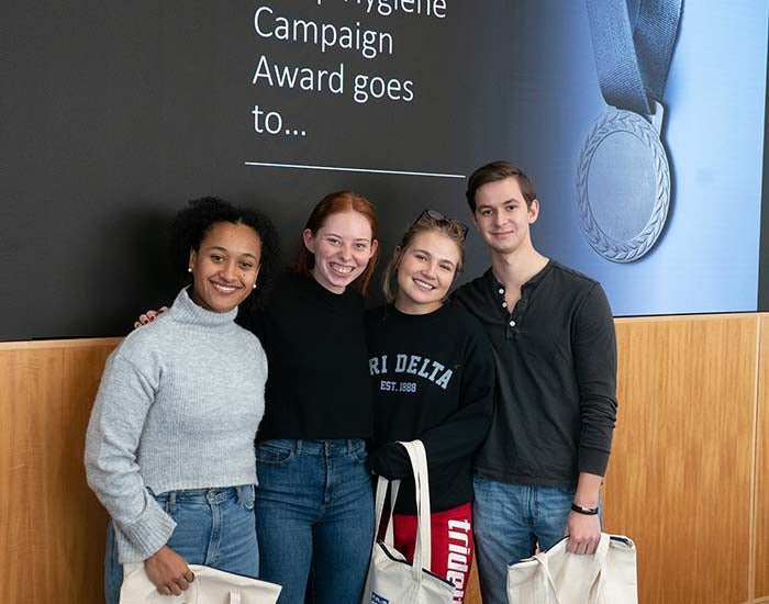 Group of people posing and the text on the screen behind them reads "..Campaign Award goes to..."