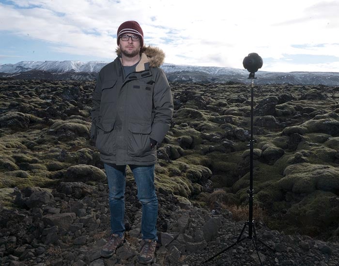 Zane Cooper standing in a craggy field in Iceland with a VR camera