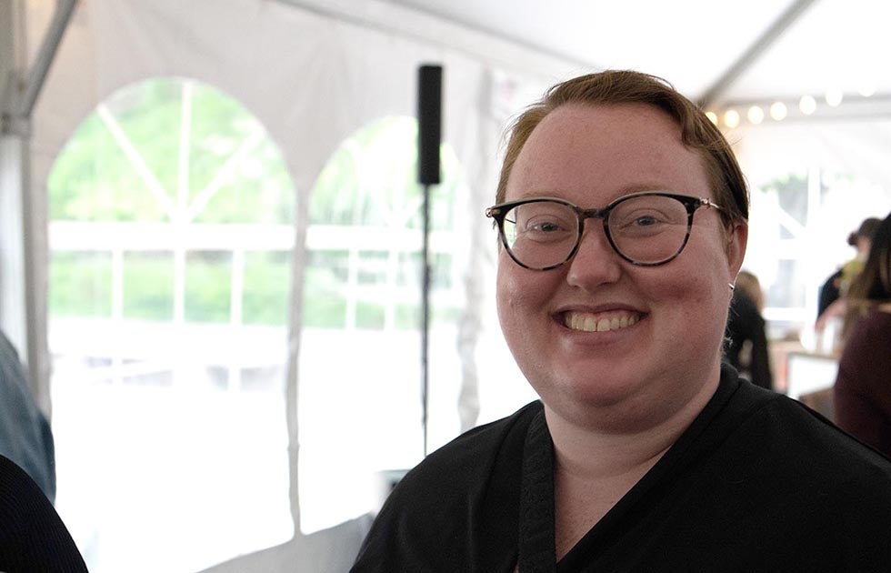 Kate Okker-Edging in a tent with several people in the background