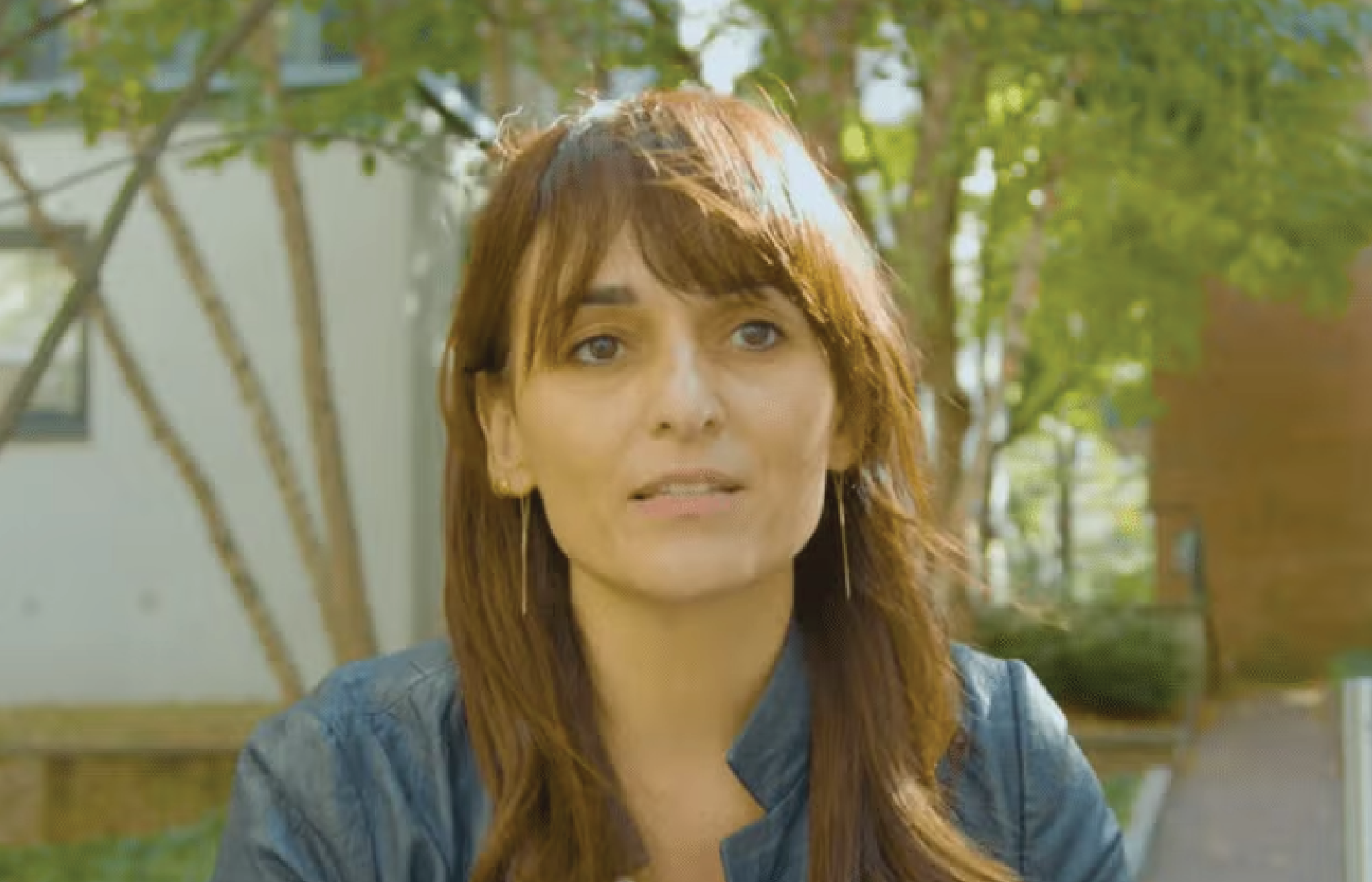 Sandra González-Bailón_Gallery Sandra González-Bailón speaking outdoors, with trees and a building in the background