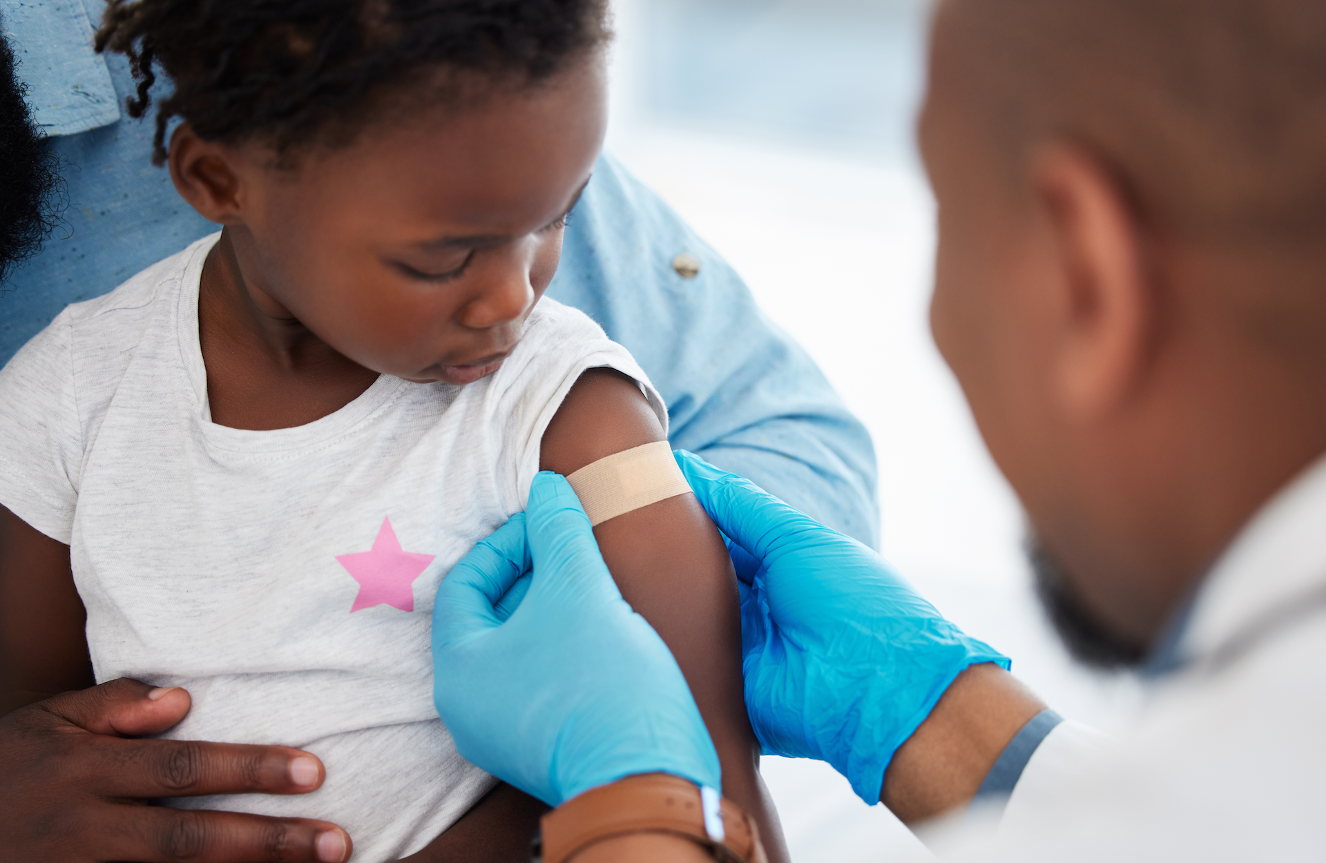 child receiving a vaccine from doctor