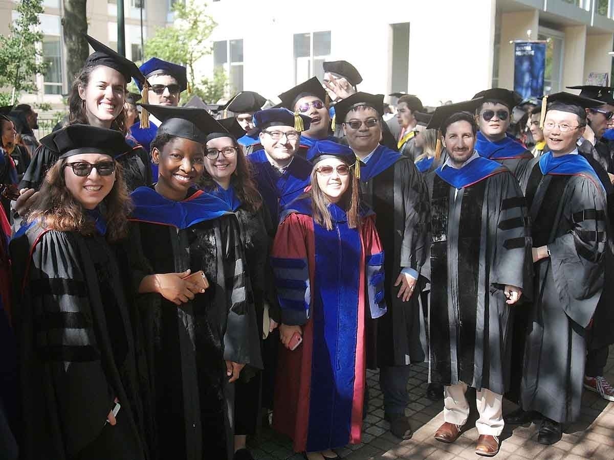 Group of people posed outside wearing PhD graduation regalia