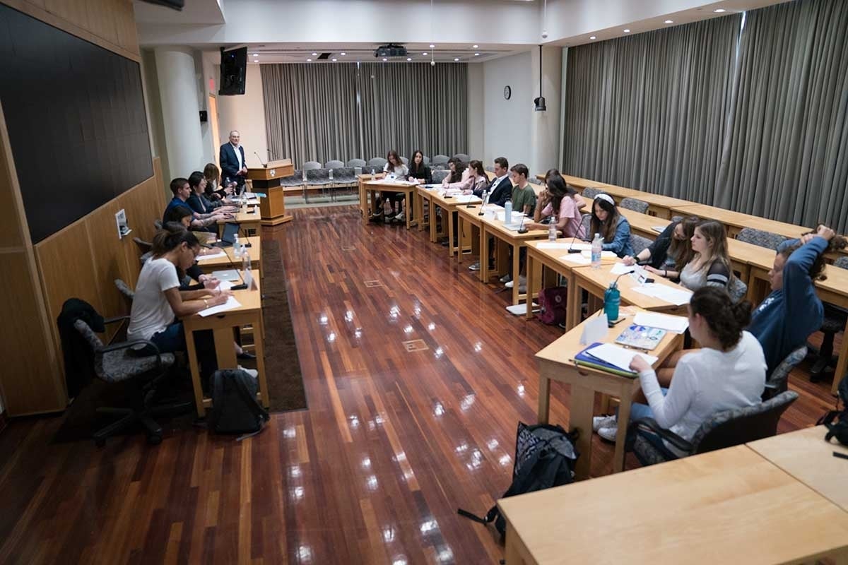 Group of students sitting and gathered in a circle during the mock press conference