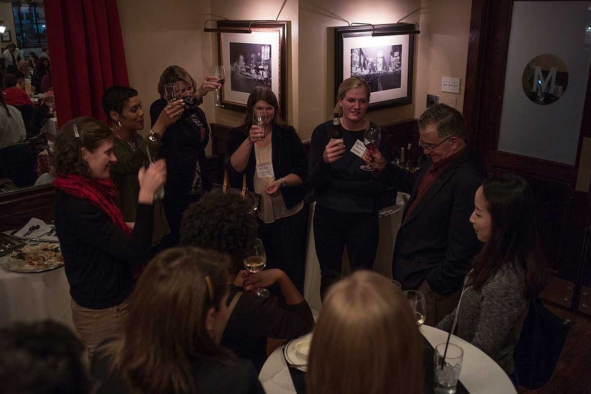 Overhead view of attendees of the event in a circle raising their glasses for a toast