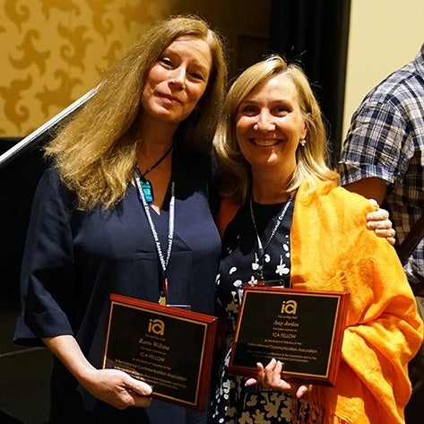 Karin Wilkins and Amy Jordan pose with plaques