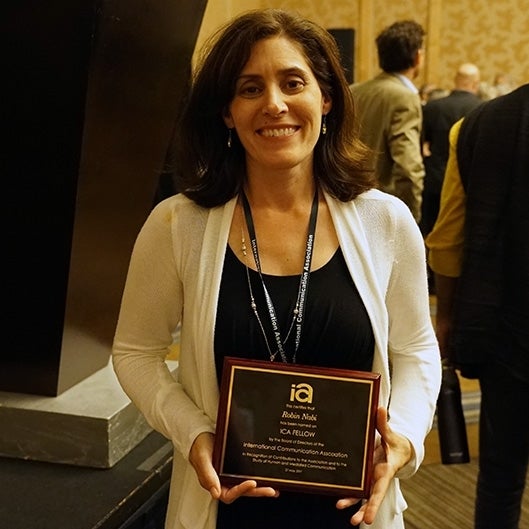 Robin Nabi poses with plaque