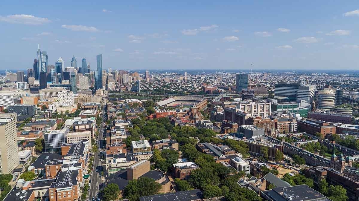 Aerial view over Penn's campus with the skyline of Philadelphia in the background