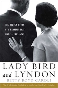 Cover of Betty Boyd Caroli's book 'Lady Bird and Lyndon'. The top two-thirds of cover is an image of an old male-female couple with their backs towards the camera. They are in formal wear.The wife has her hand on her husband's back, and above her hands reads the words 'the hidden story of a marriage that made a president'. Below the image is the title and tutor name. At bottom of cover is the quote "Caroli redefines the First Lady as an iron fist in a white glove." by Vanity Fair.  
