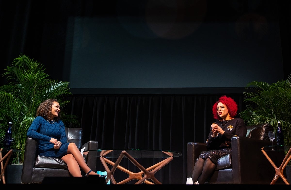 Sarah J. Jackson and Nikole Hannah-Jones sit on chairs on a stage having a discussion 