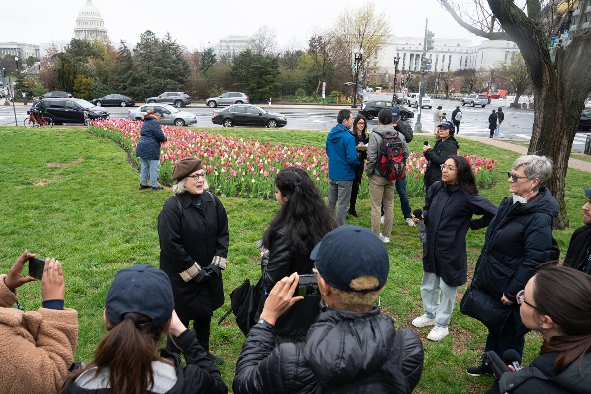 Annenberg students stand in a circle outside on the National Mall interviewing Barbara Cochran