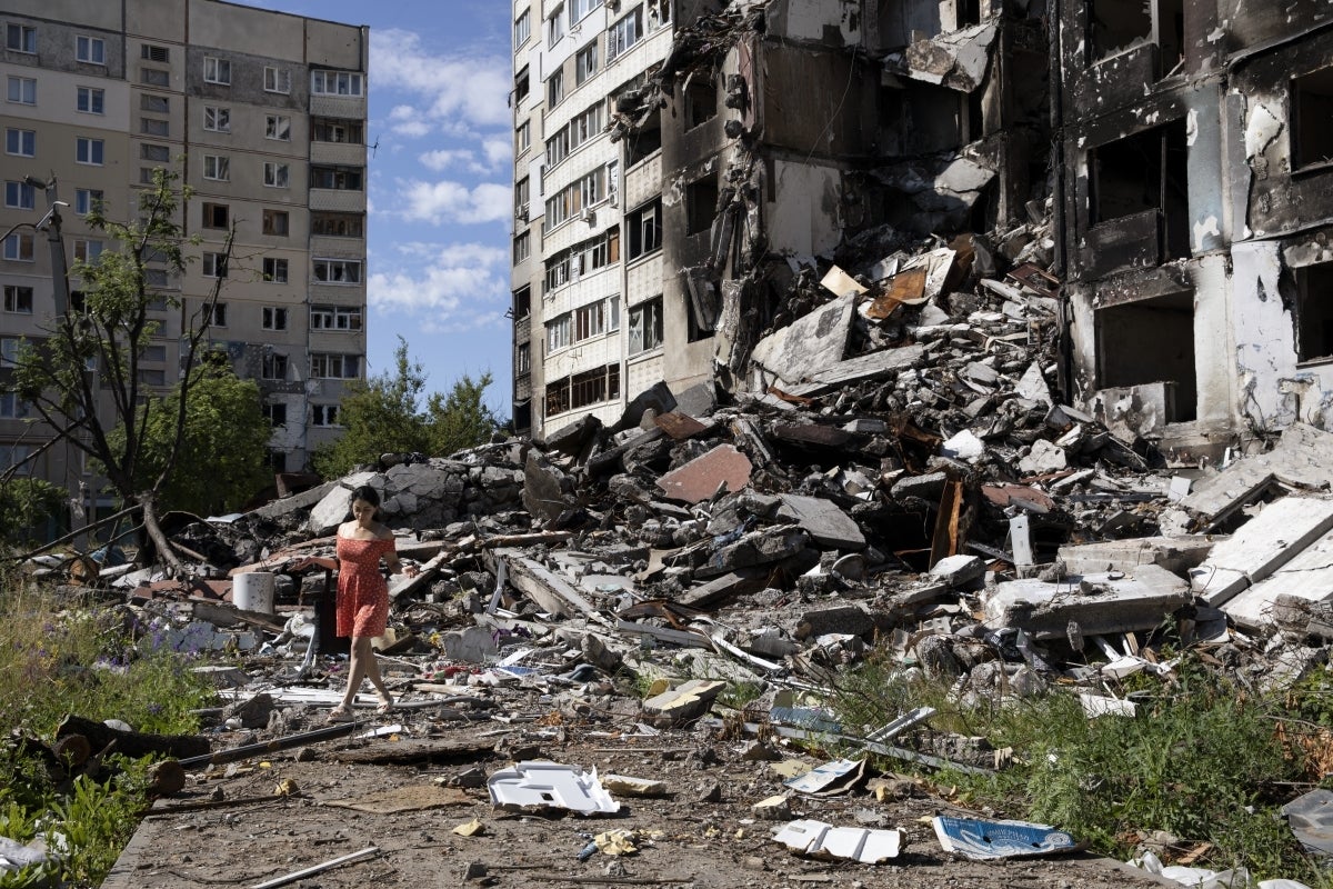 A woman examines the remains of a residential building in Ukraine's second largest city, Kharkiv, in June 2022. (Photo: Joseph Sywenkyj)