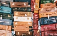 pile of suitcases; Photo Credit: Caroline Selfors / Unsplash