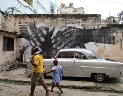 Cuba mural 700 x 550.jpg Mural showing hands with 1950s car in front of it and a man walking with a child on his shoulders while holding the hand of another