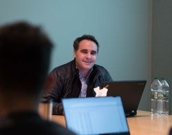 Damon Centola in classroom 700 x 550.jpg Damon Centola sitting behind a desk in a classroom smiling