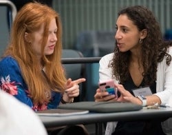 Sophie and Kelly talking.jpg Two students talking sitting in a classroom