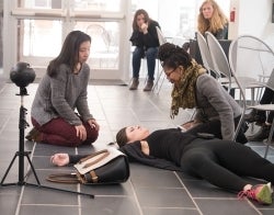 AC_Narcan_700x550.jpg A woman lying on ground simulating an overdose, with three students looking at her