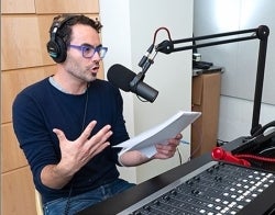 DanielGorenstein_700x550.jpg Daniel Gorenstein wearing headphones and speaking into a microphone as he records a podcast