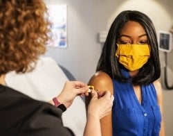 Nurse giving bandage after vaccine by CDC for Unsplash 700 x 550.jpg Nurse putting a band-aid on a young patient's arm, presumably after a vaccine. The patient wears a face mask. Photo credit: CDC/Unsplash
