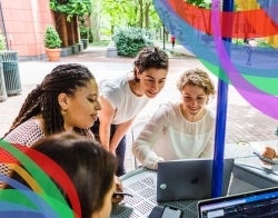 DMSI Checkerbaord Four women happily working on laptops at an outdoor table