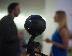 VR COVID 700 x 550.jpg A VR camera close up with people blurred behind it