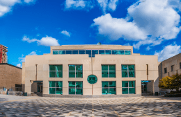 a bright blue sky above the Annenberg school building from the Locust Walk side