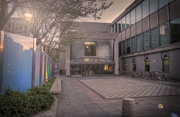 Walnut Street entrance to Annenberg School, a brown building with green transparent windows