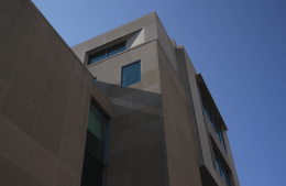 angled view from the ground of the beige stone Annenberg building with a blue sky in the background